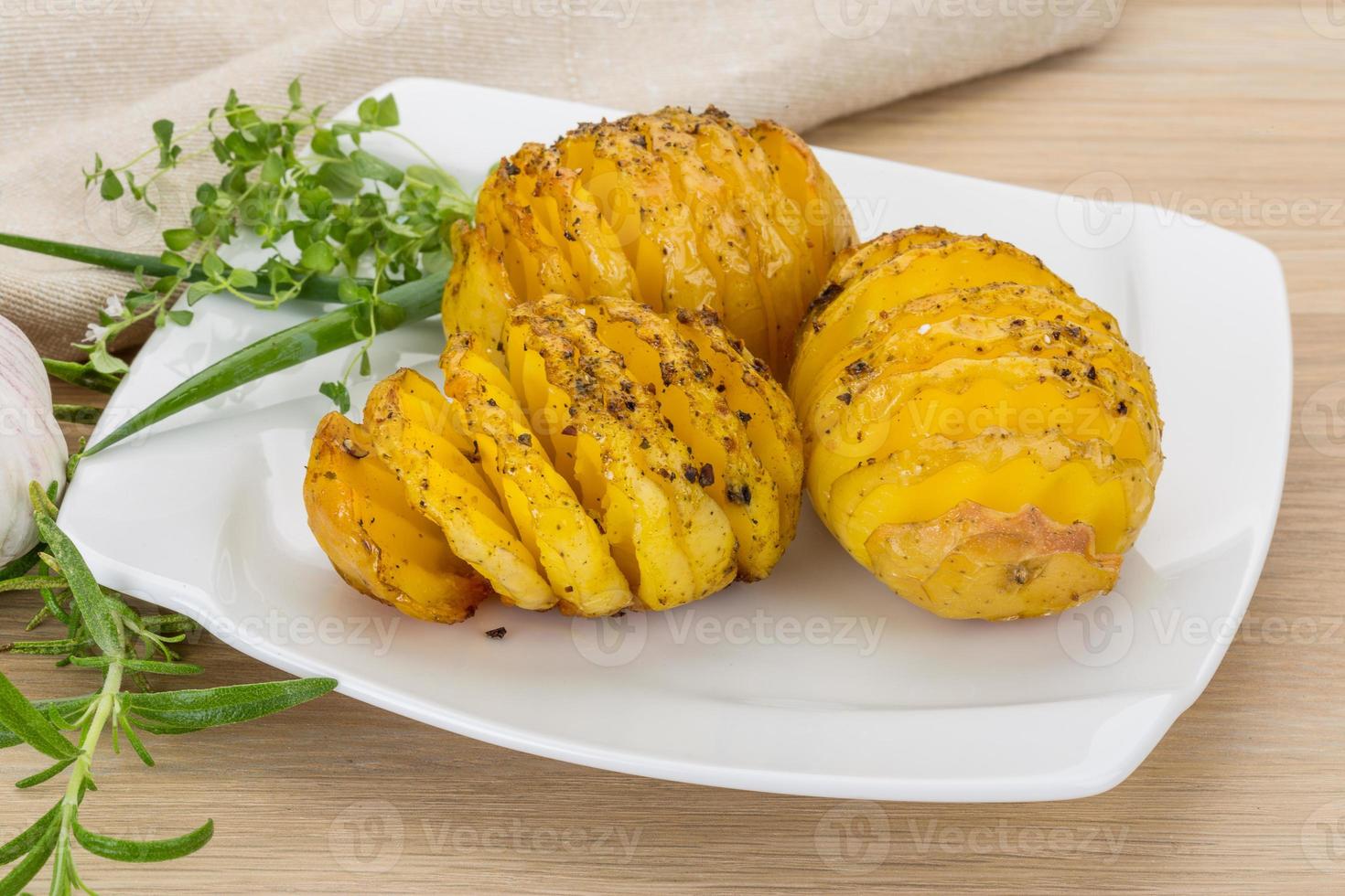 patata al horno en el plato y fondo de madera foto