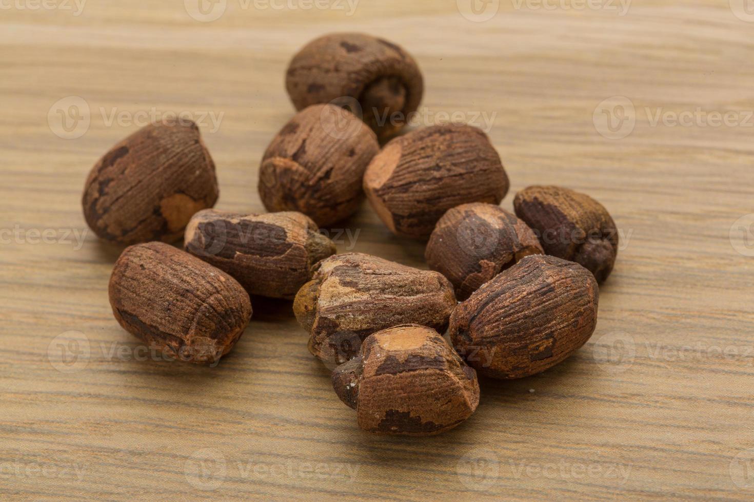 Small nutmeg on wooden background photo
