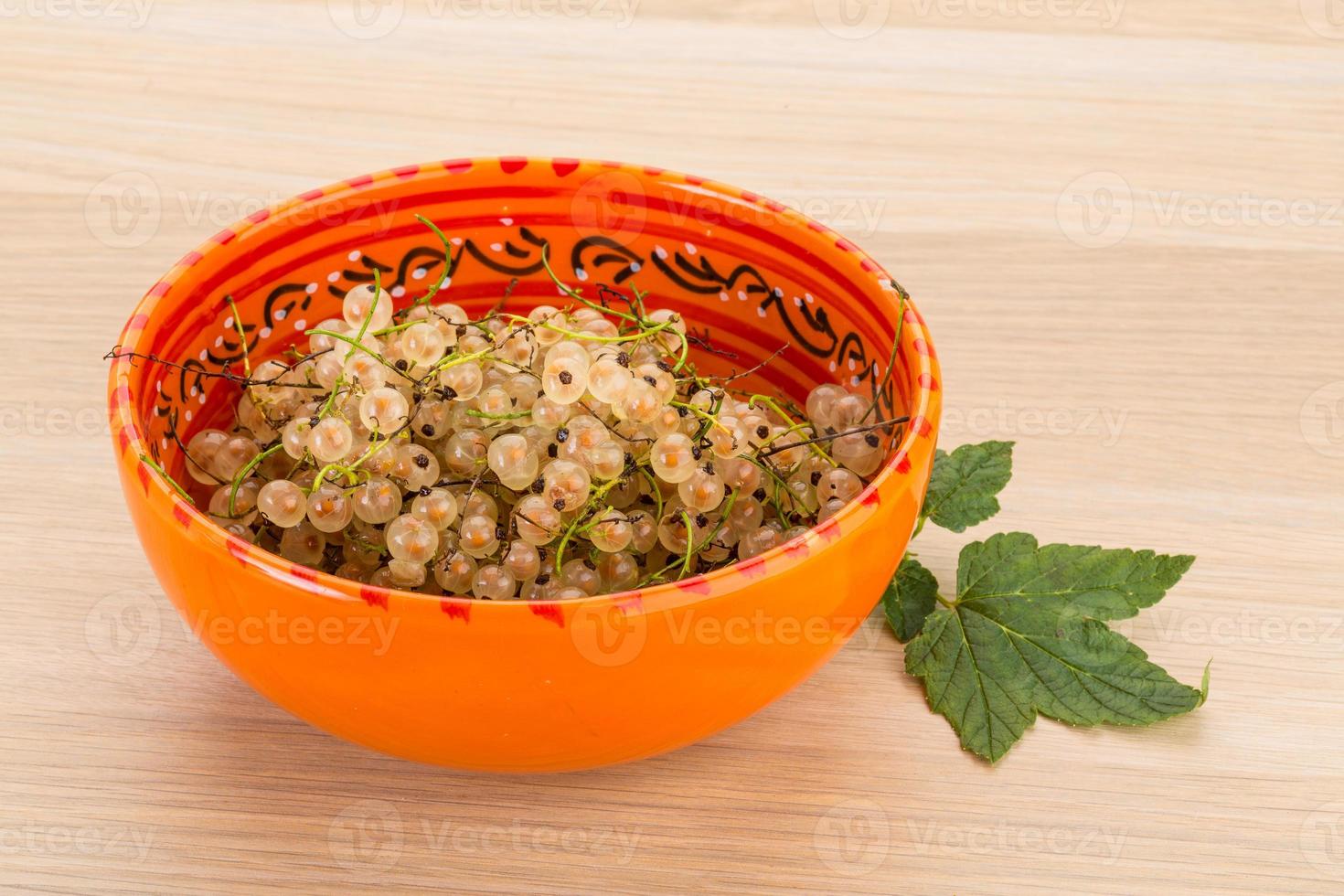White currant in a bowl on wooden background photo