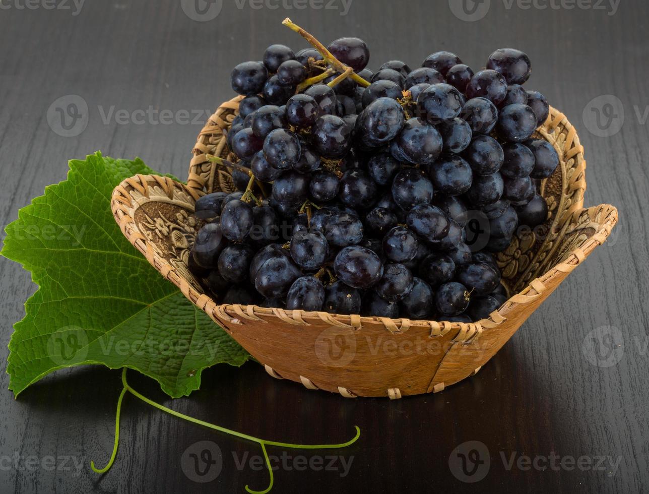 Grape in a basket on wooden background photo