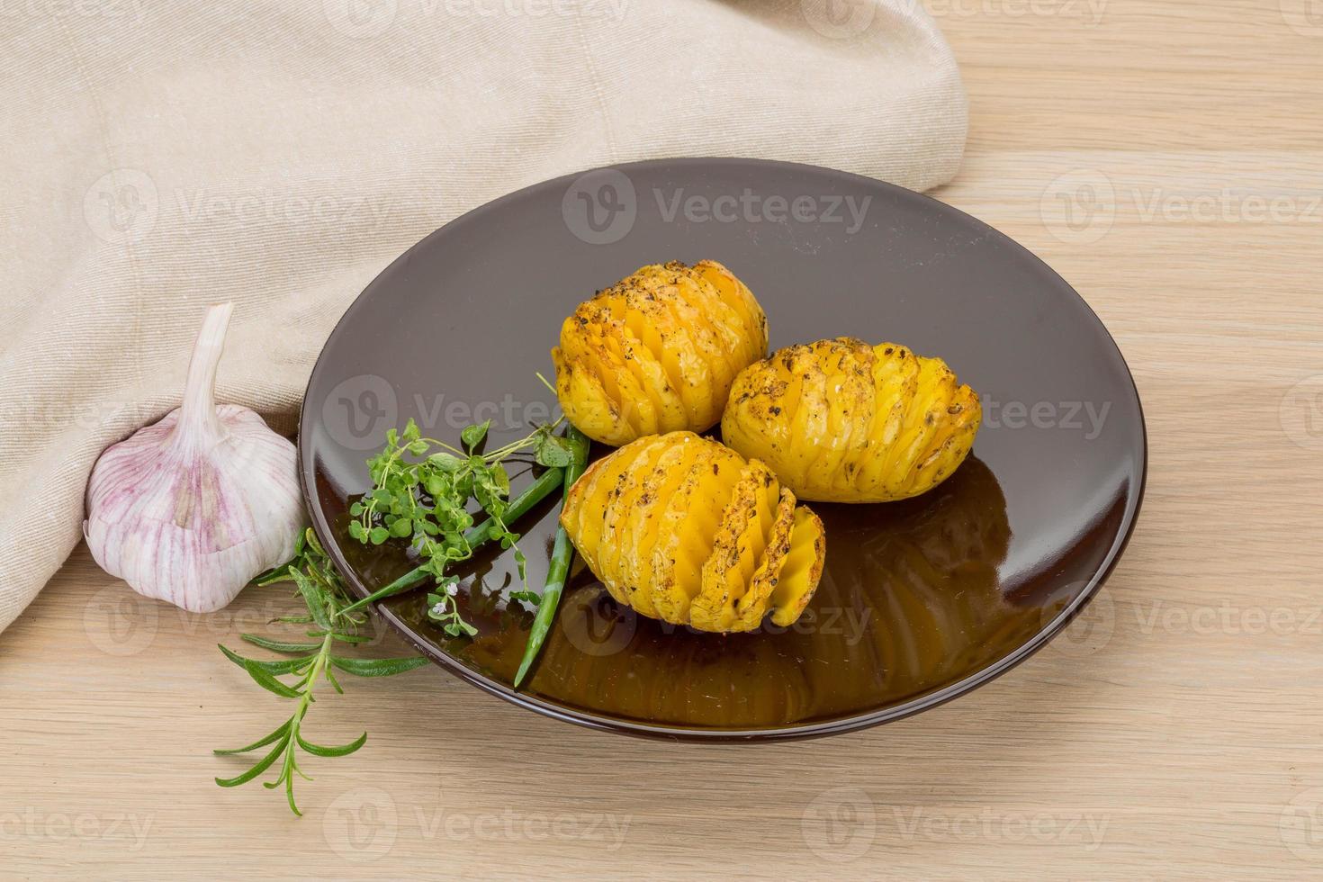 patata al horno en el plato y fondo de madera foto