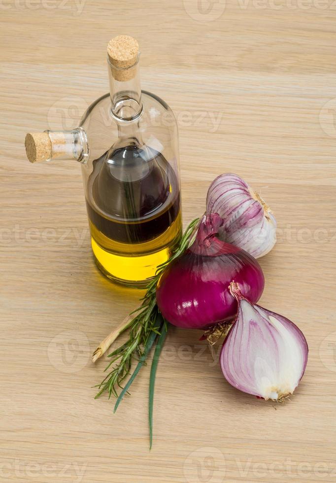 Oil, vinegar with onion on wooden background photo
