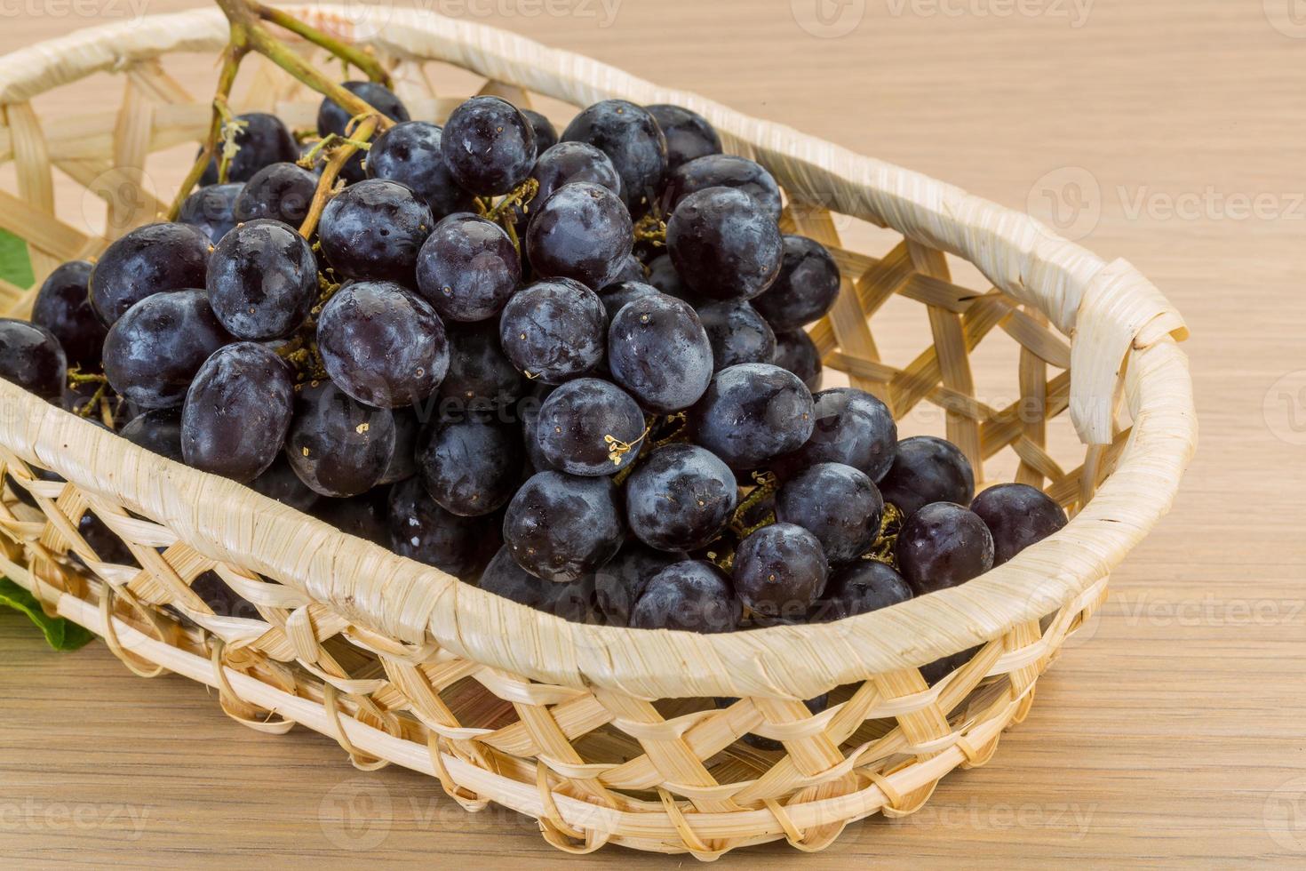 Grape in a basket on wooden background photo