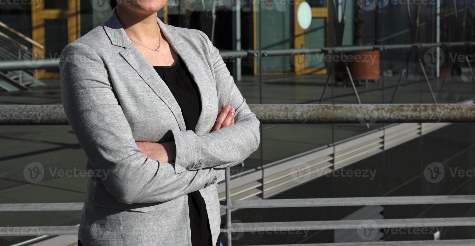 mujer profesional anónima con camisa negra y chaqueta traje gris en un entorno urbano Foto de stock en Vecteezy