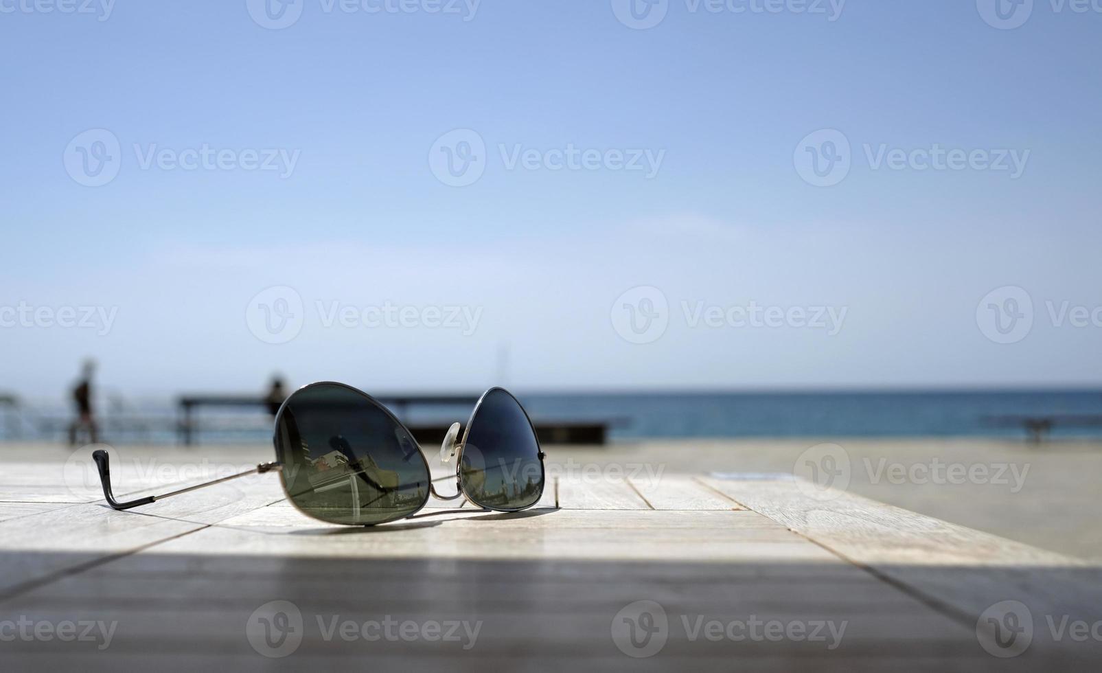 Sunglasses on a table near the coast photo