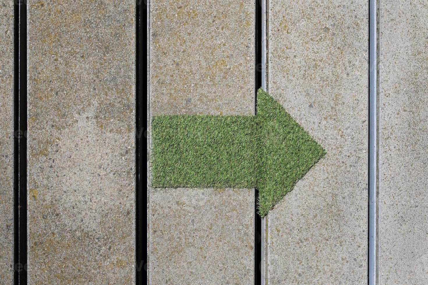 Green arrow made out of a patch of grass pointing to the right photo