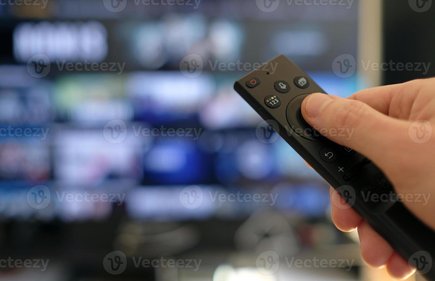 Hand holding remote control - binge watching a TV show photo