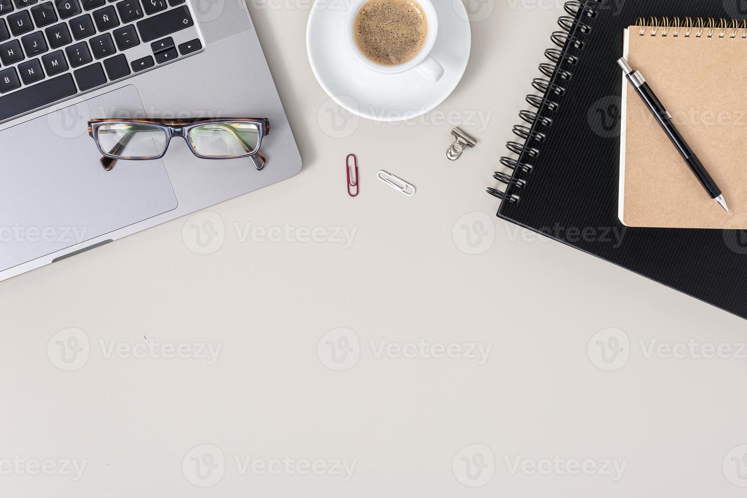 Flat lay office desk table with laptop, notebook, eyeglasses and cup of coffee. Workspace with copy space photo
