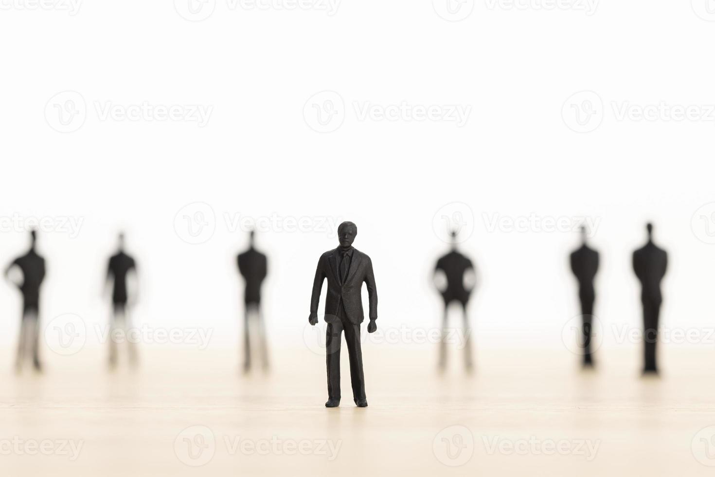 Leader posing with her team in blurred background. Successful team leader concept. Man figurine. Copy space photo
