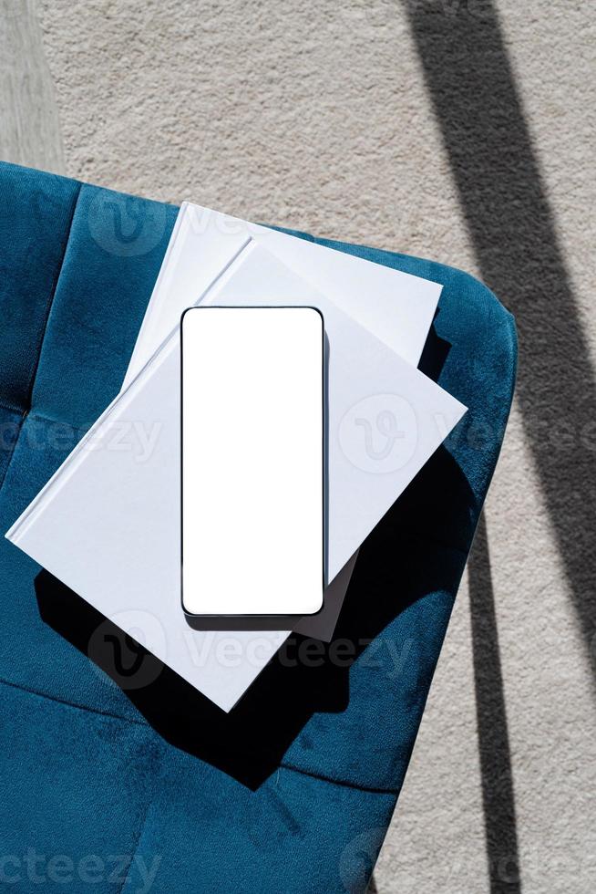 smartphone with isolated screen on blue chair. At home interior. photo