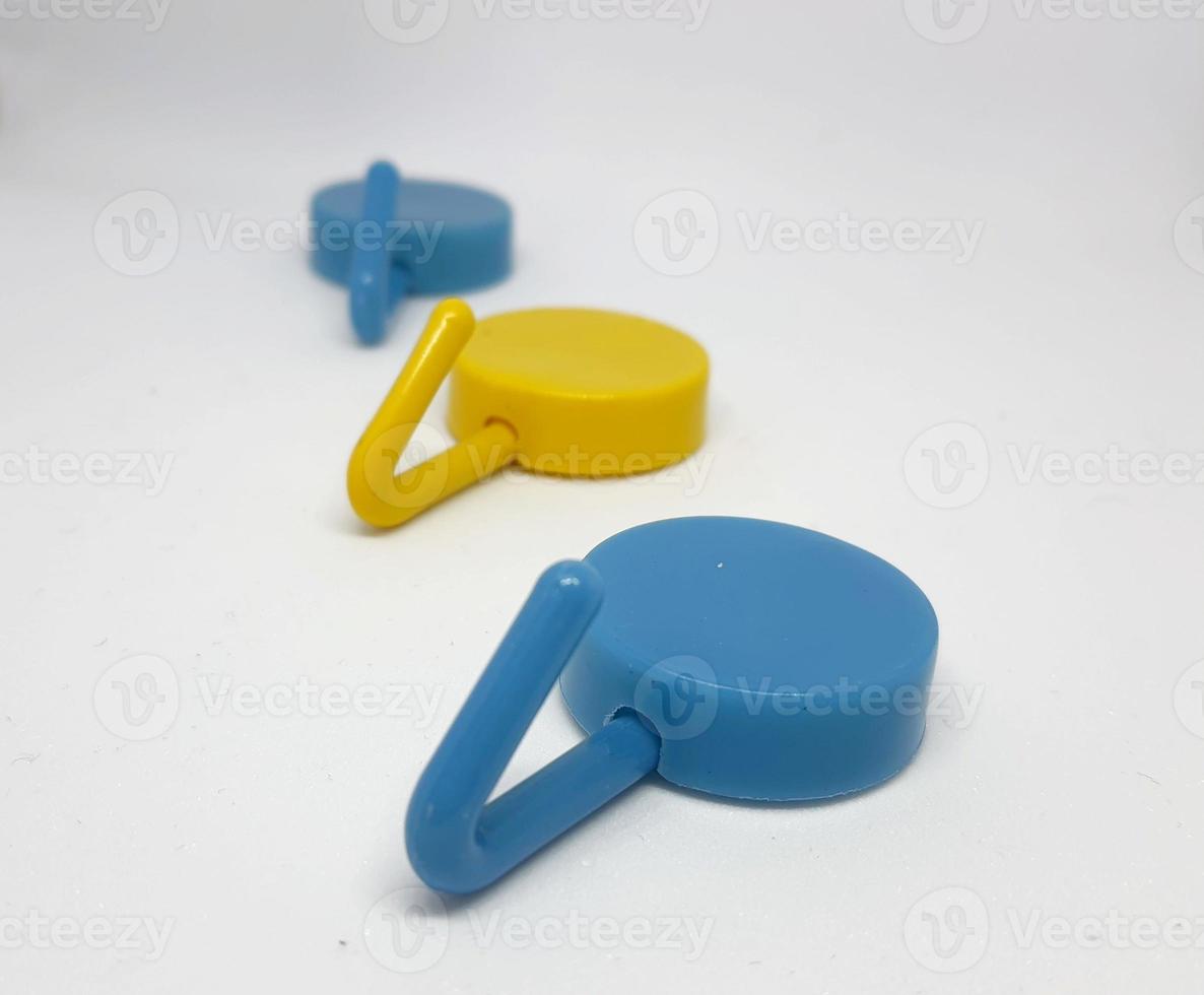 Isolated white photo of three round coat hangers with blue and yellow colors.