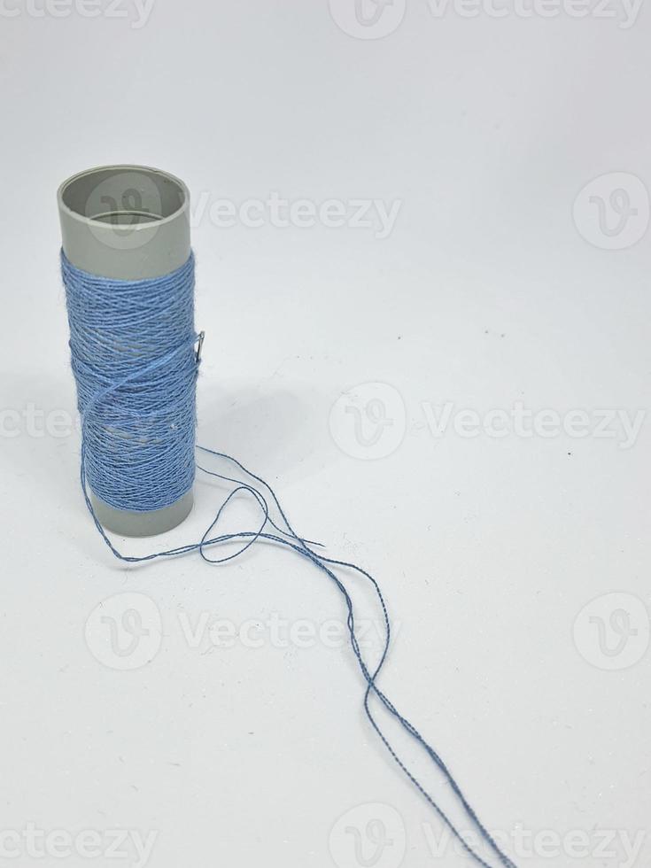 Isolated white photo of a blue sewing thread.