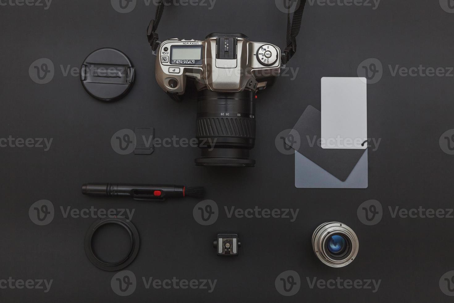 Photographer workplace with dslr camera system, camera cleaning kit, lens and camera accessory on dark black table background. Hobby travel photography concept Flat lay top view copy space photo