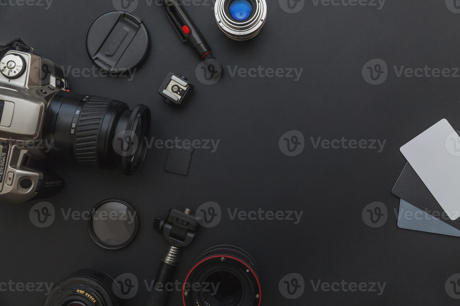 Photographer work place with dslr camera system, camera cleaning kit, lens and camera accessory on dark black table background. Hobby travel photography concept. Flat lay top view copy space. photo