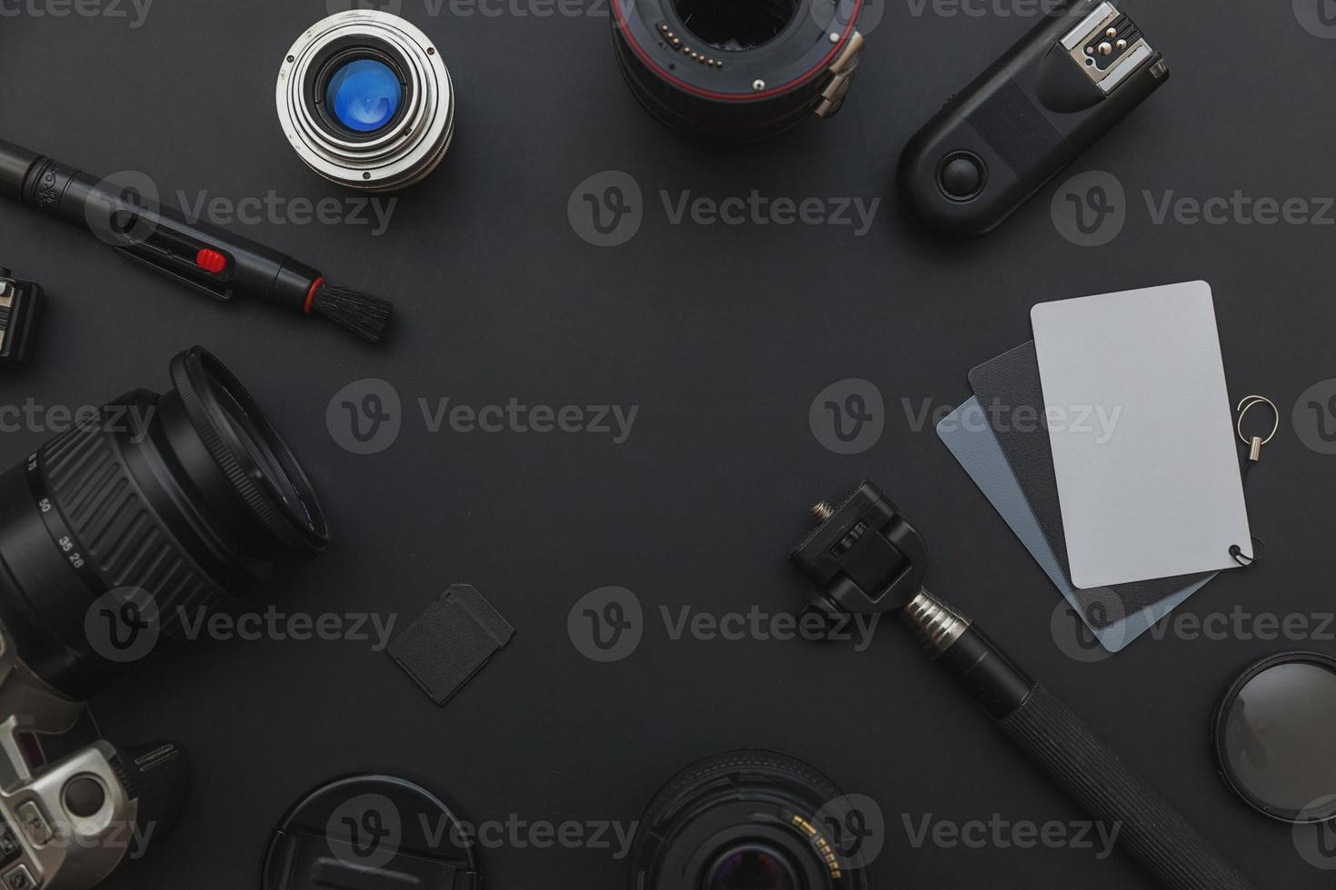 Photographer work place with dslr camera system, camera cleaning kit, lens and camera accessory on dark black table background. Hobby travel photography concept. Flat lay top view copy space. photo