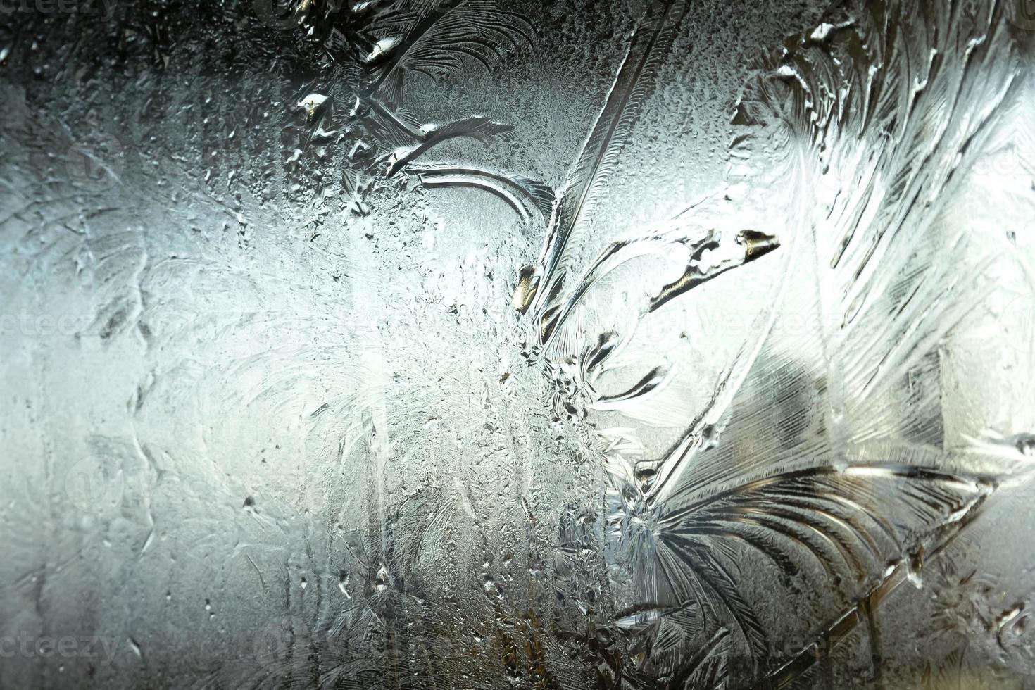 Frozen winter window with shiny ice frost pattern texture. Christmas wonder symbol, abstract background. Extreme north low temperature, natural Ice snow on frosty glass, cool winter weather outdoor. photo