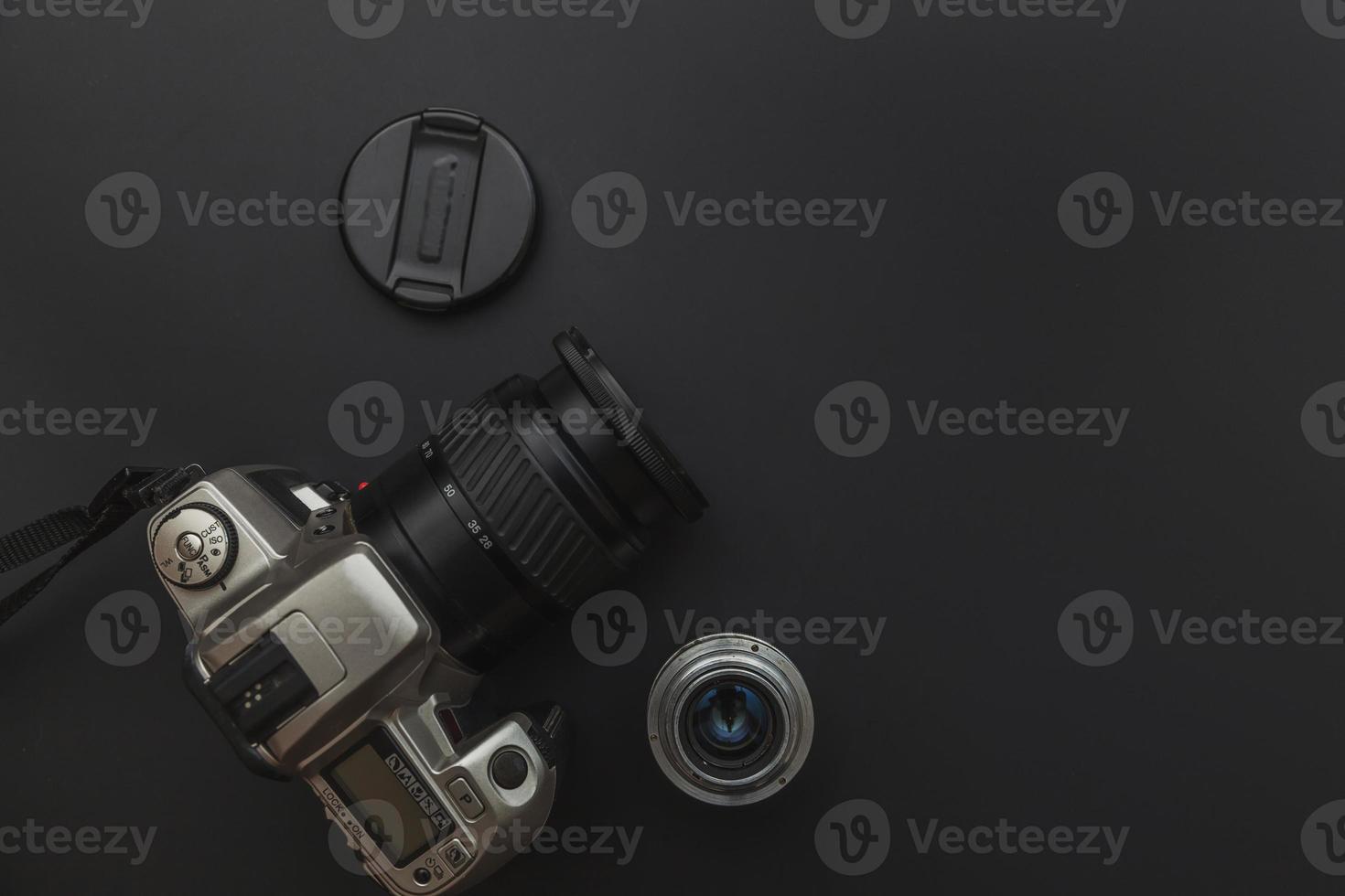 Photographer workplace with dslr camera system and lens on dark black table background. Hobby travel photography concept. Flat lay top view copy space. photo