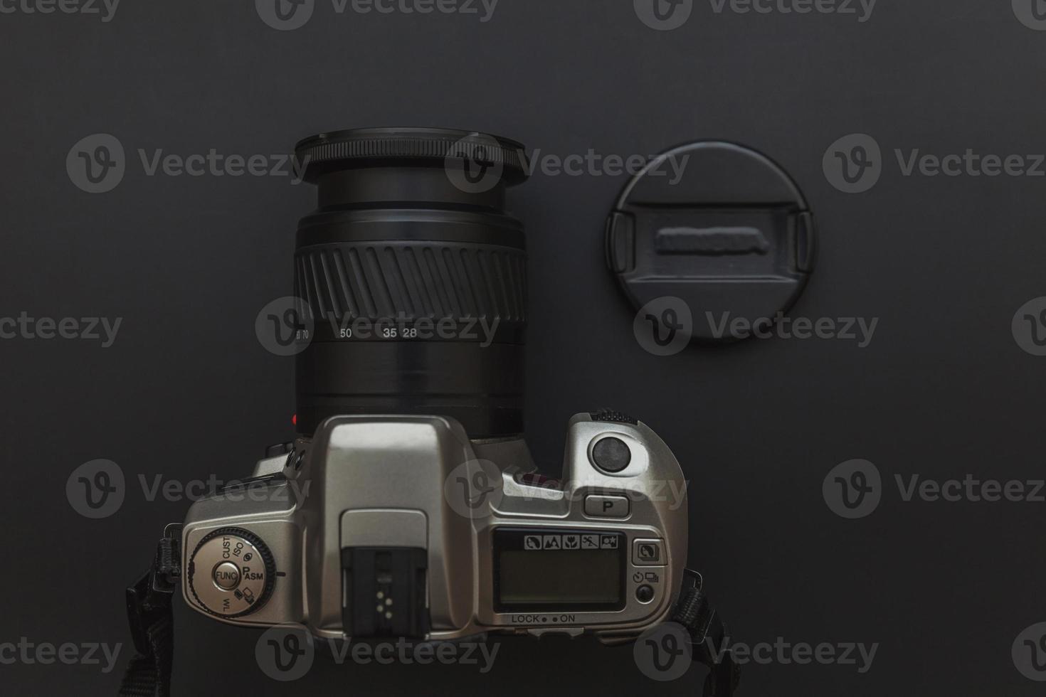 Photographer workplace with dslr camera system on dark black table background. Hobby travel photography concept. Flat lay top view copy space. photo