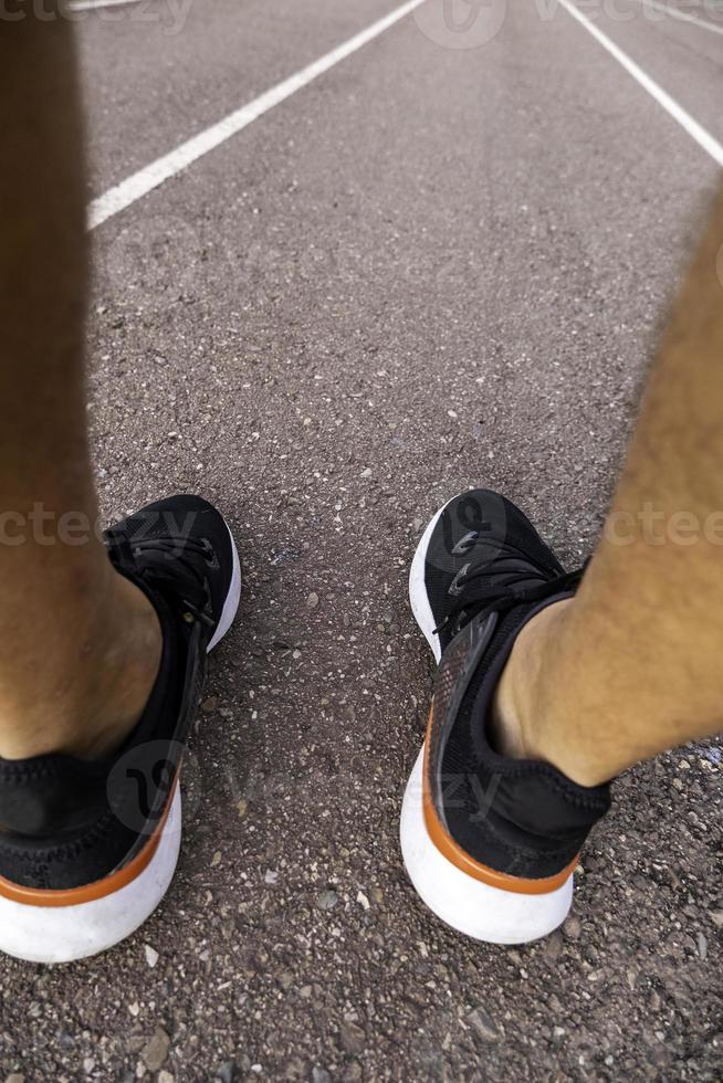 Man's feet on running track photo