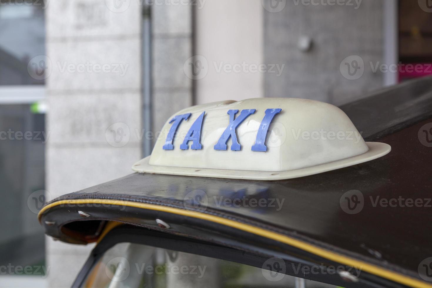 Taxi sign on the roof of a tuk tuk photo
