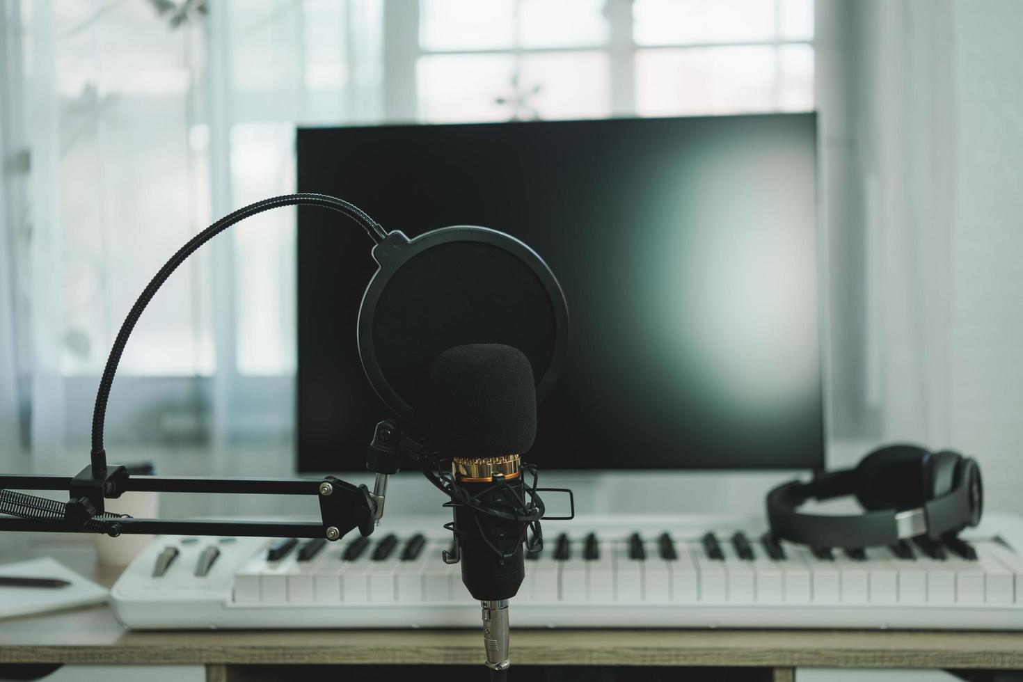 micrófono de estudio de condensador de estudio de música en casa, piano y auriculares blancos para mezclar canciones de producción. equipo de grabación de estudio en casa. concepto de instrumento musical. foto