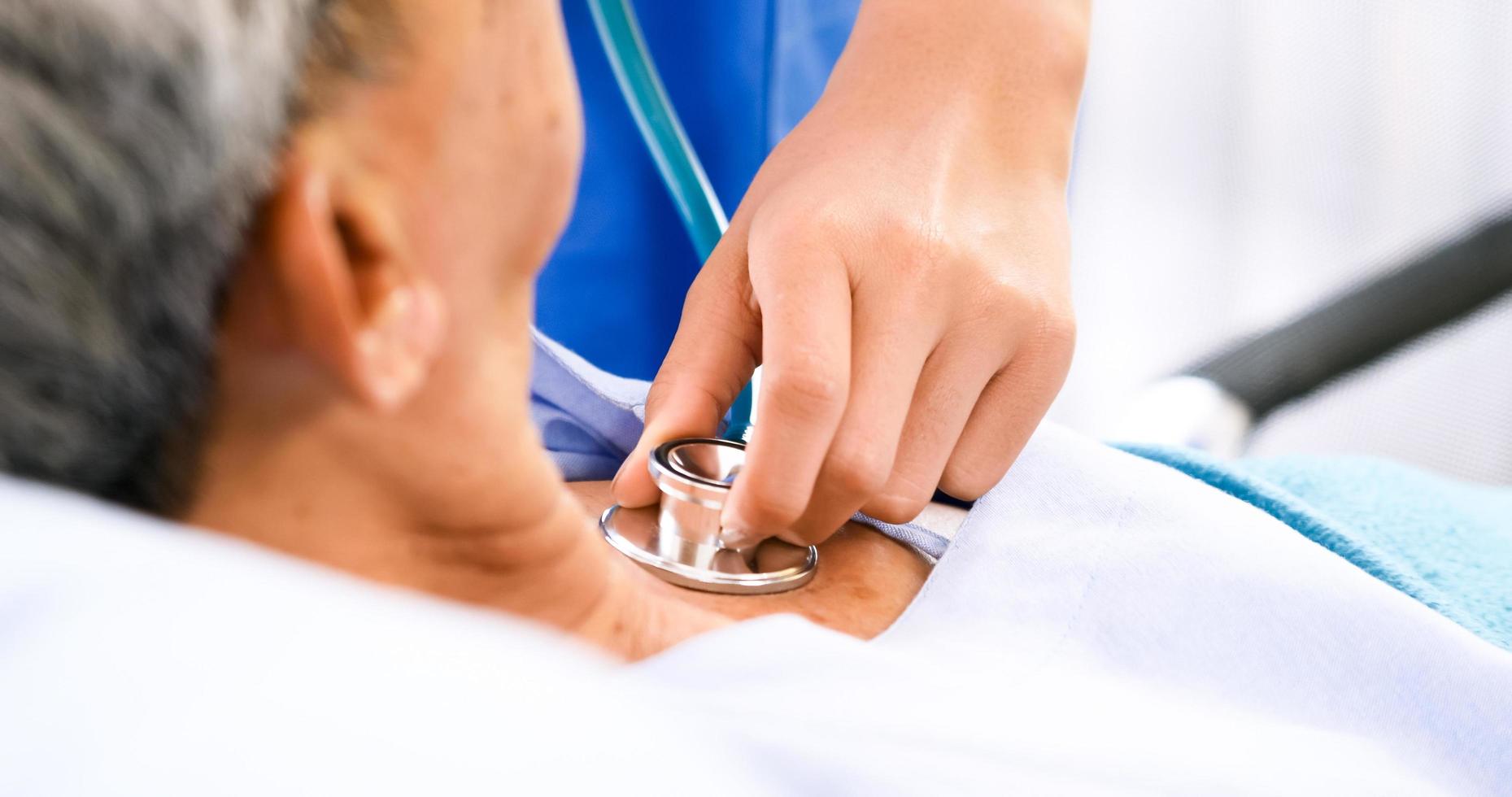 Female medical assistant checkup adult patient at hospital room. photo