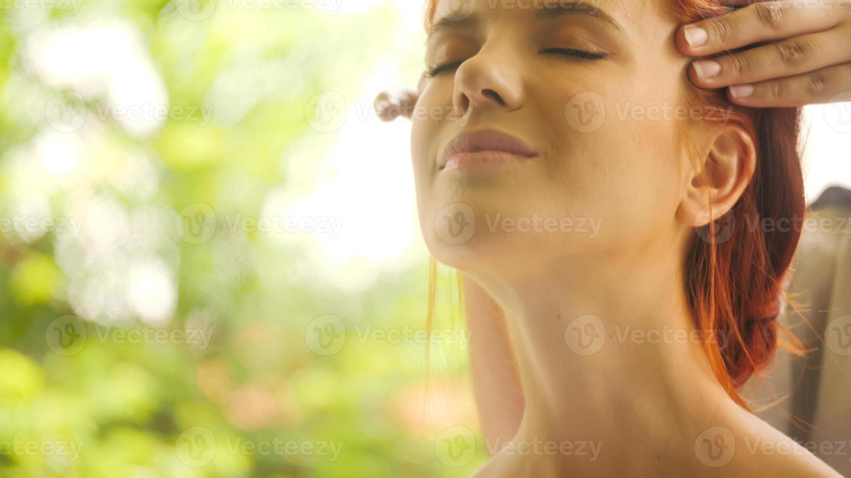 hermosa mujer caucásica recibiendo masaje en la cabeza en el spa. foto