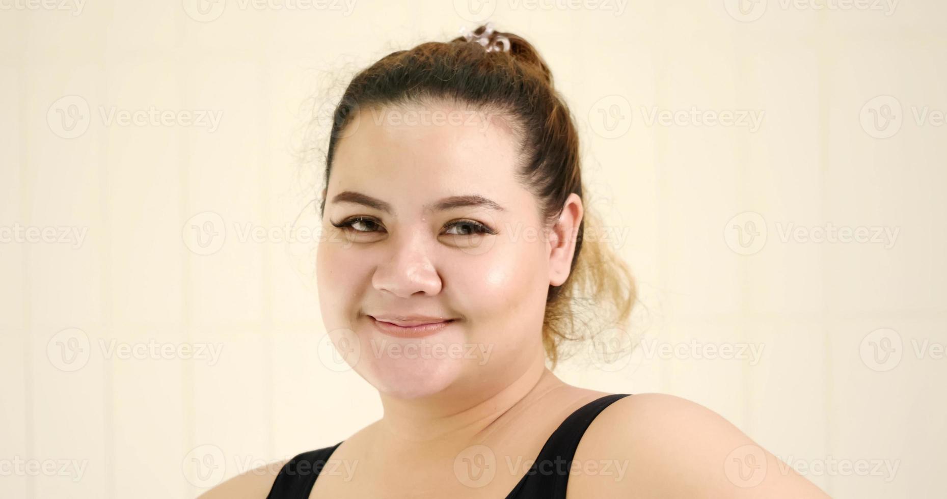 mujer gordita feliz de pie en la habitación. foto