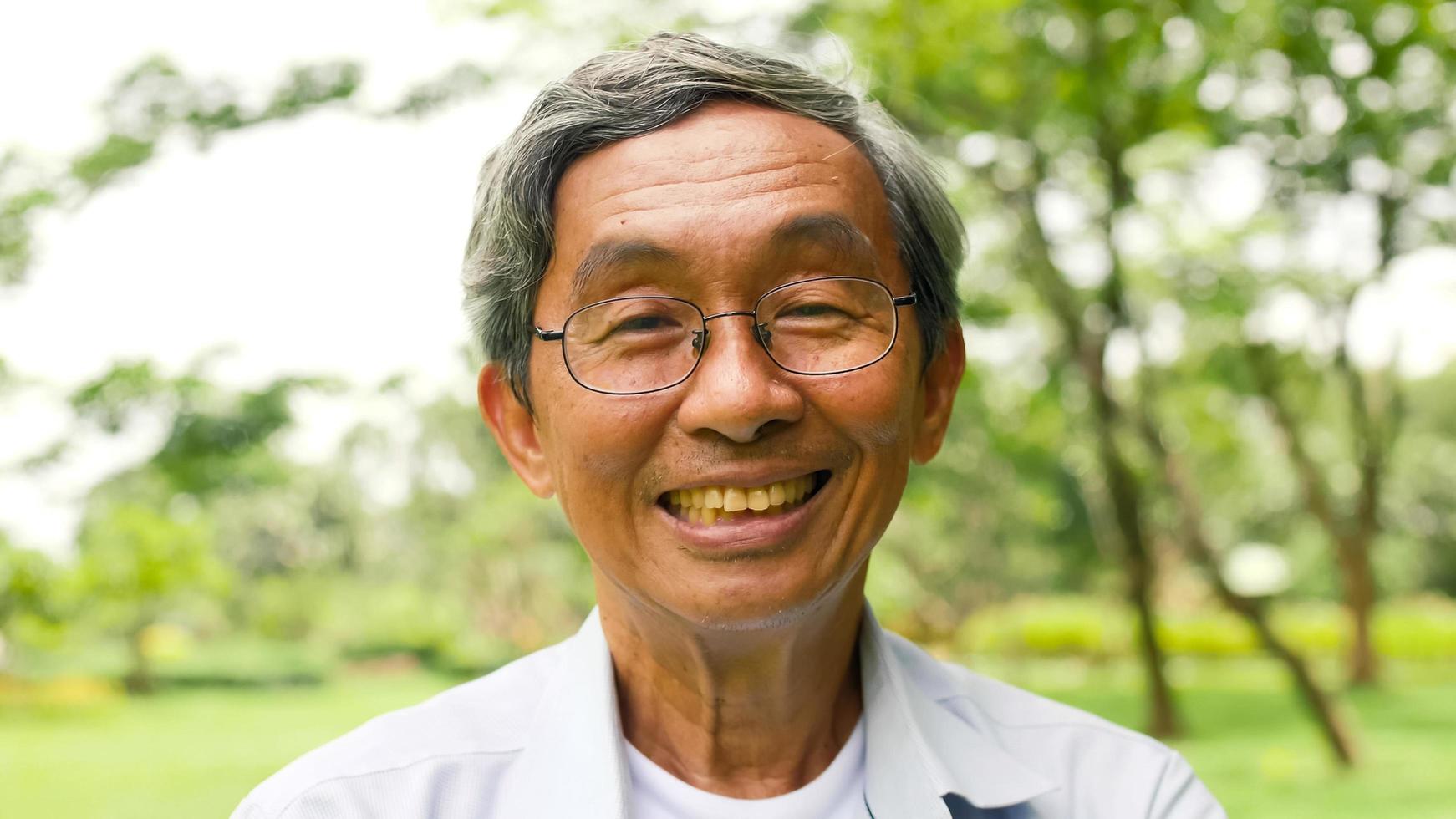 Happy asian man standing at the park. photo