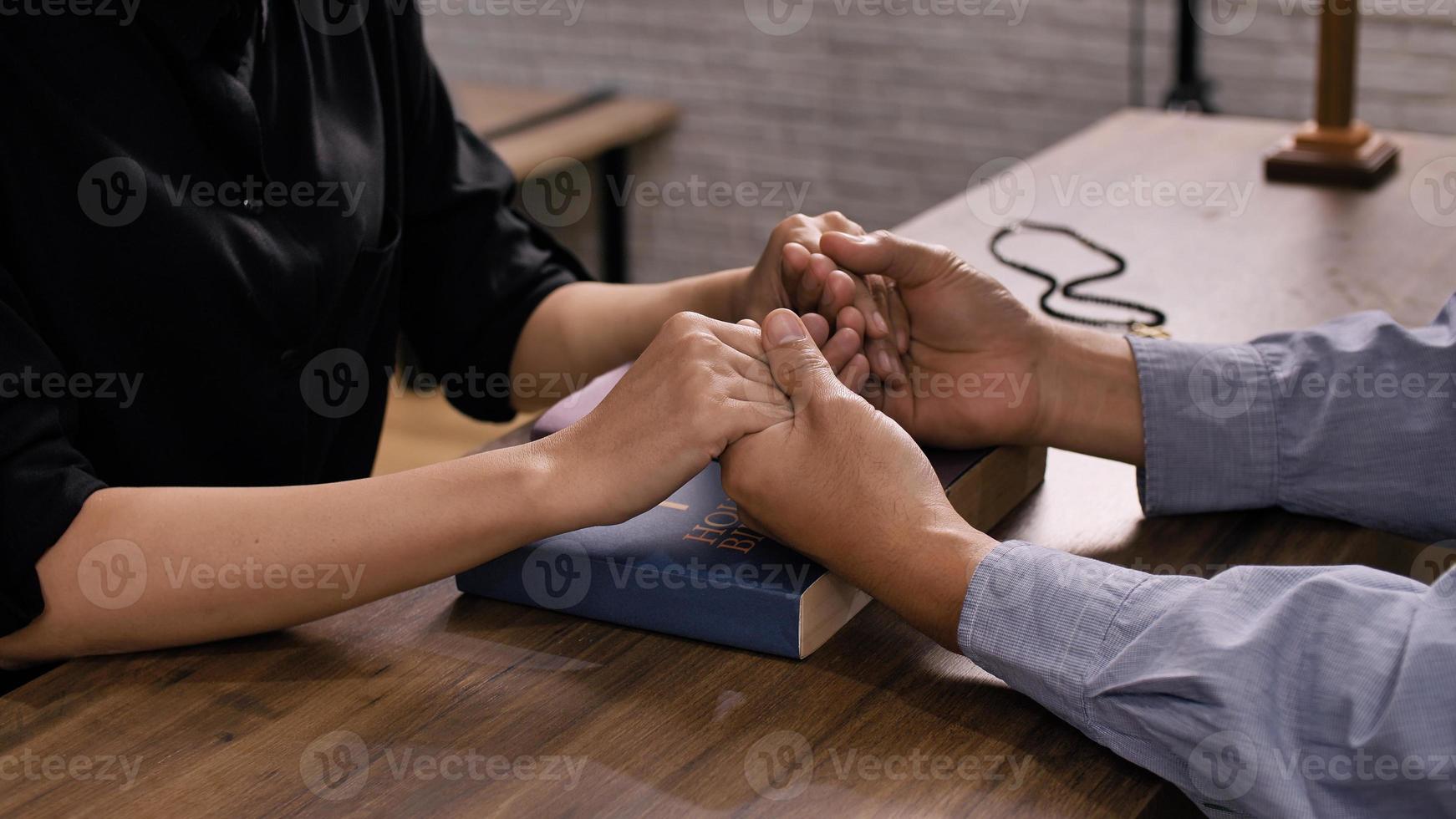 A young Asian Christian couple praying to Jesus Christ in a church. photo