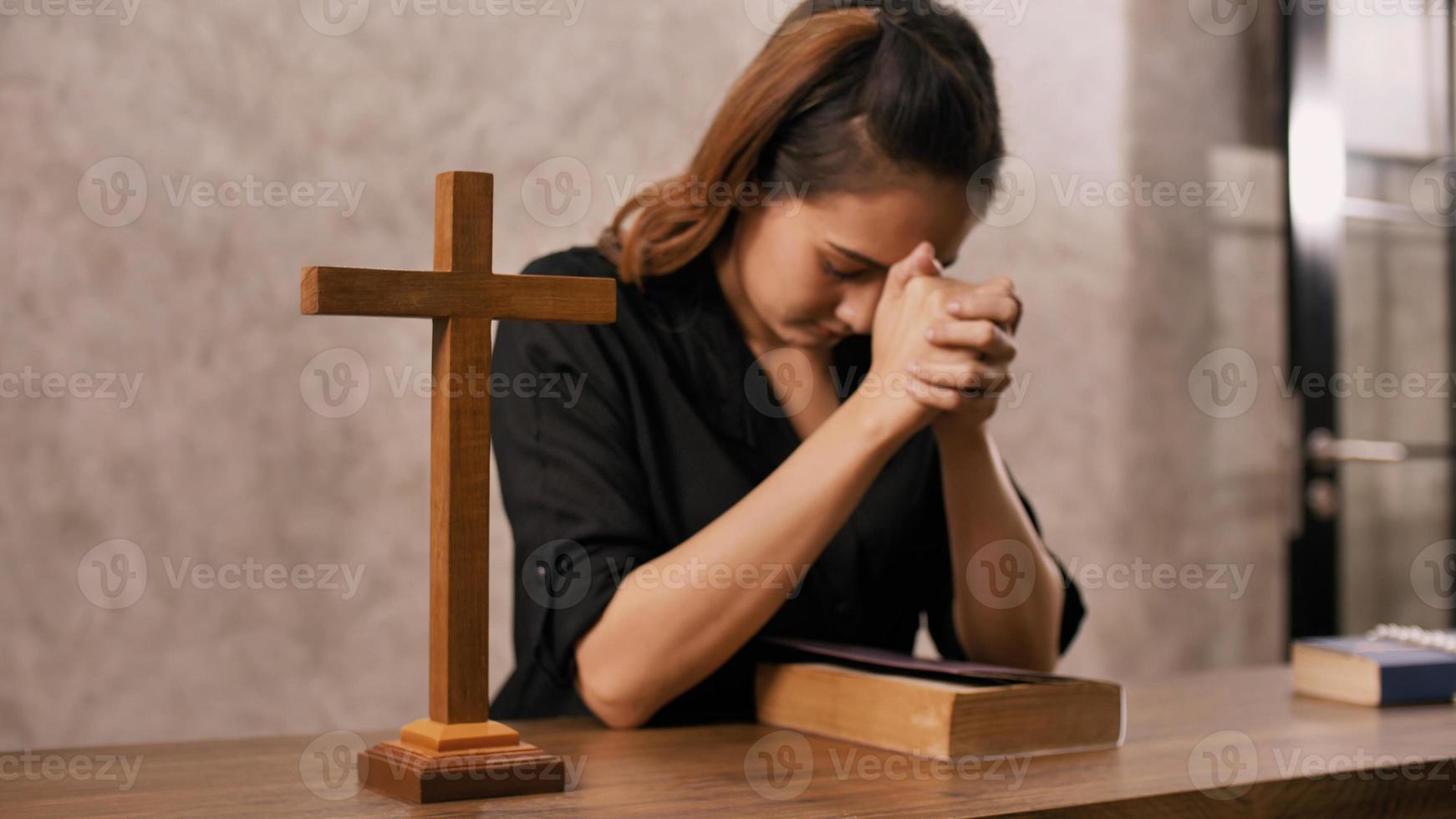 A young Asian Christian woman praying to Jesus Christ in a church. photo