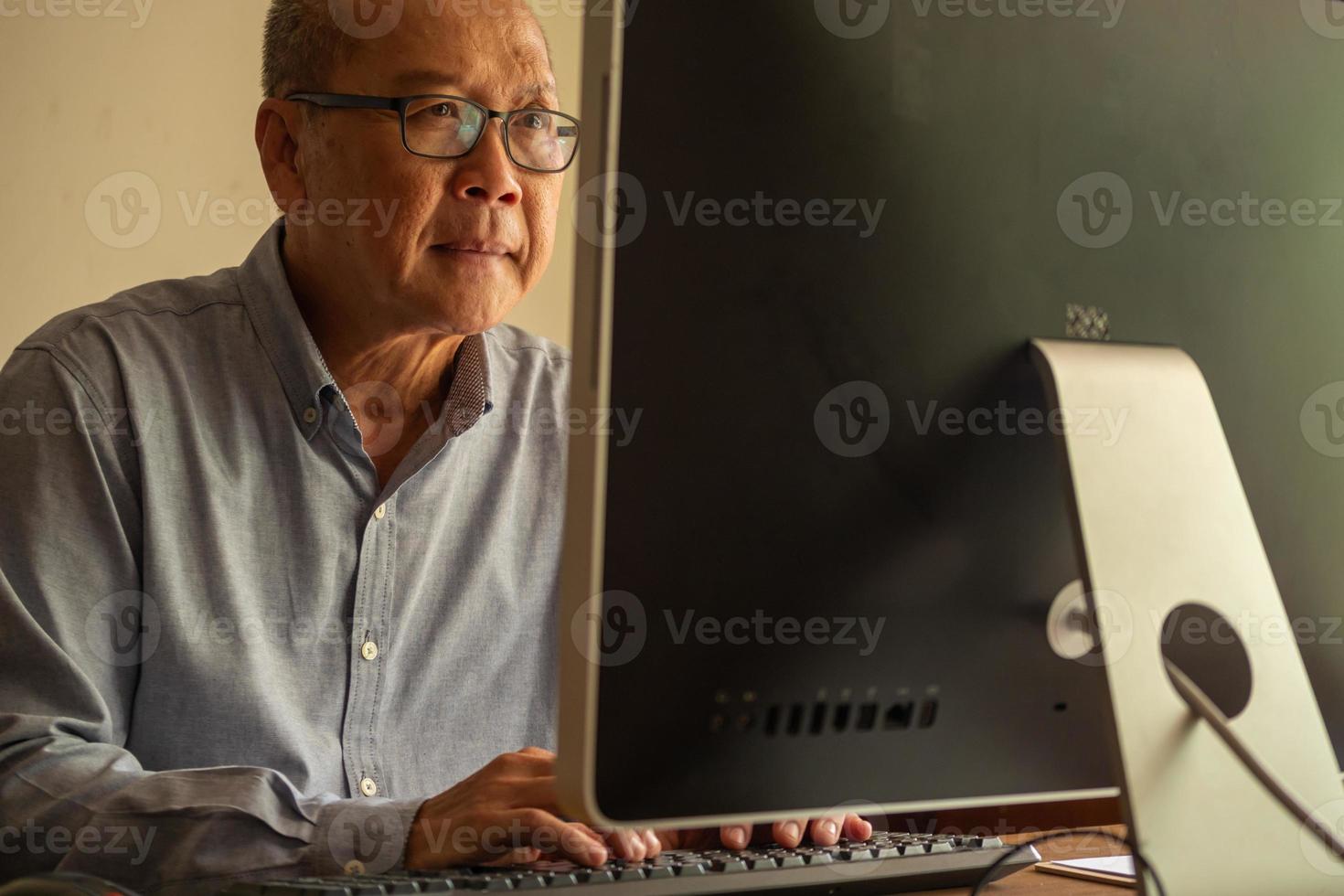 hombre de negocios asiático sentado y escribiendo en un teclado de computadora en la sala de la oficina. foto