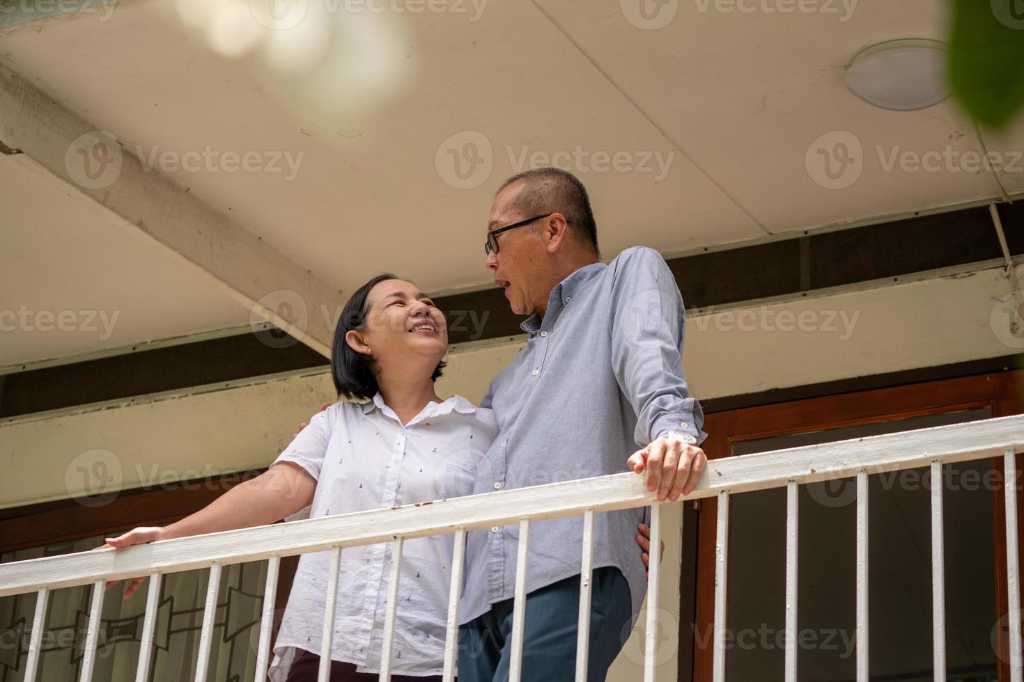 Happy asian couples standing at the balcony and talking together. photo