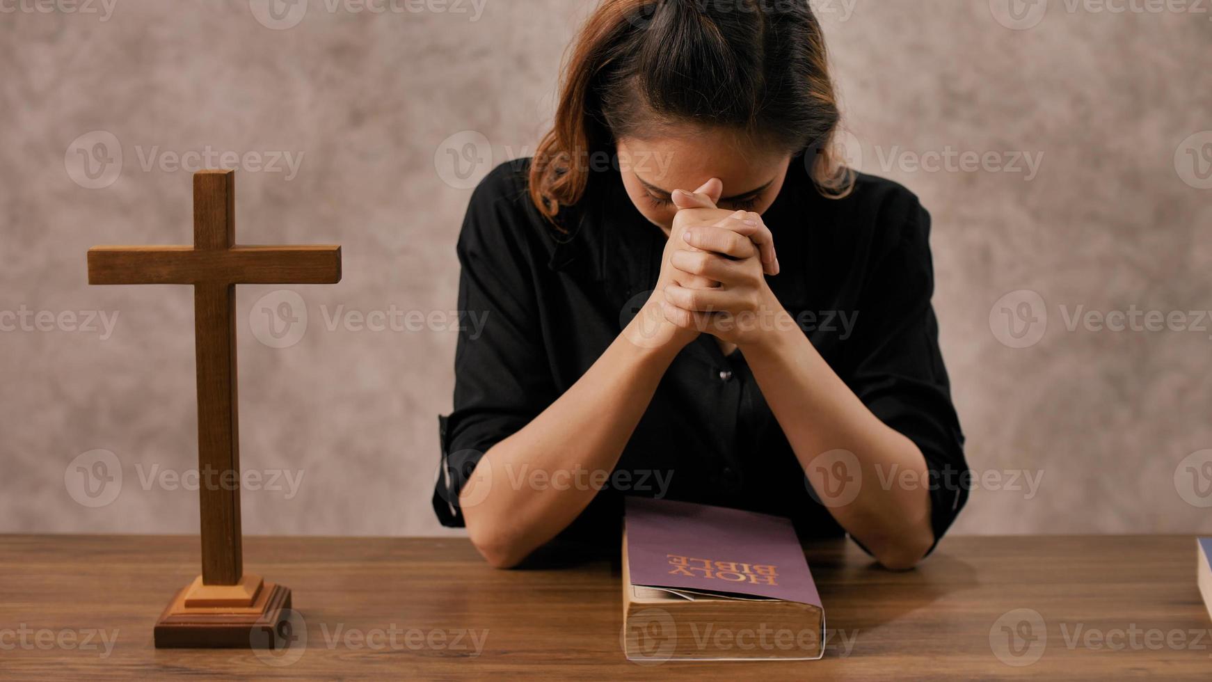 A young Asian Christian woman praying to Jesus Christ in a church. photo