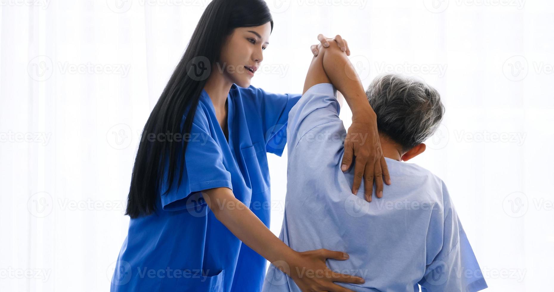 fisioterapeuta femenina haciendo fisioterapia para pacientes adultos en la habitación del hospital. foto