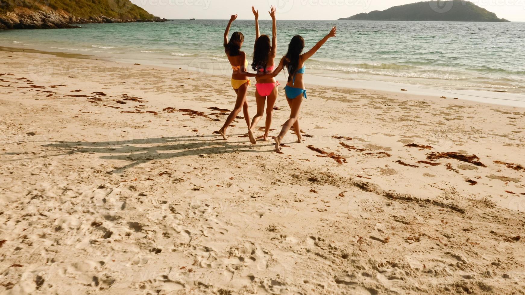 Three sexy women walking together on the beach. photo