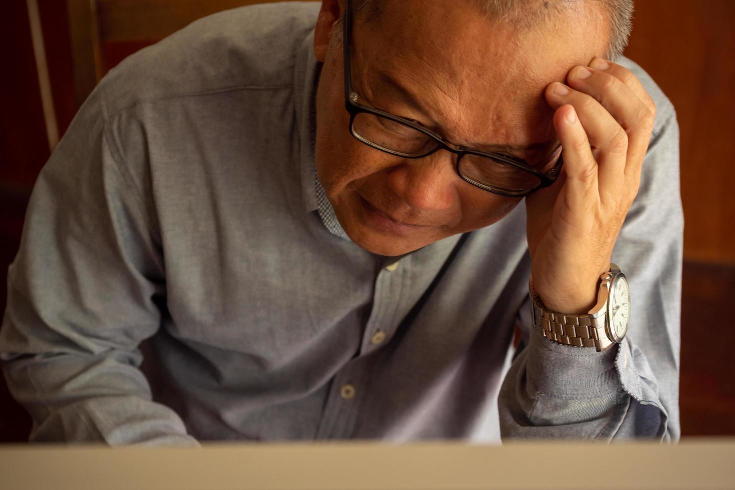 Asian businessman sitting and analyzing  his works in the office room. photo