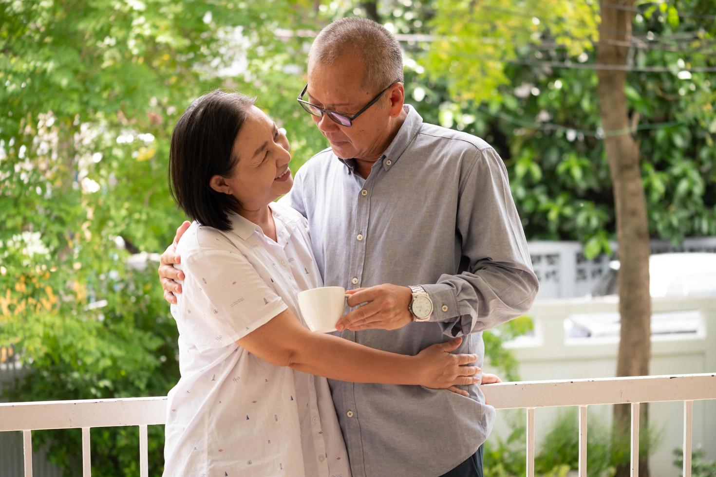 Happy asian couples standing and hugging together at the park. photo