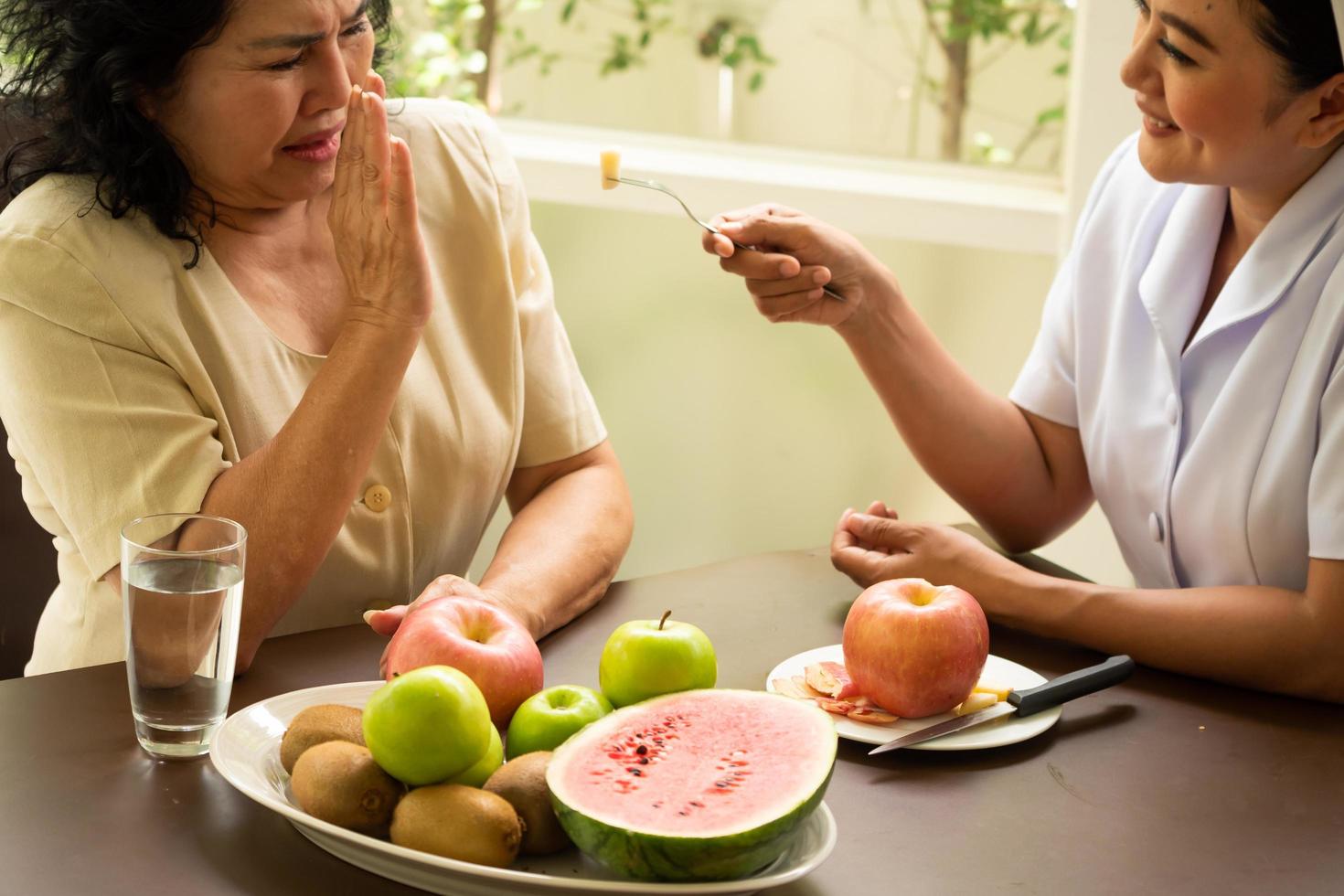 Adult female patient refusing apple from nurse. photo