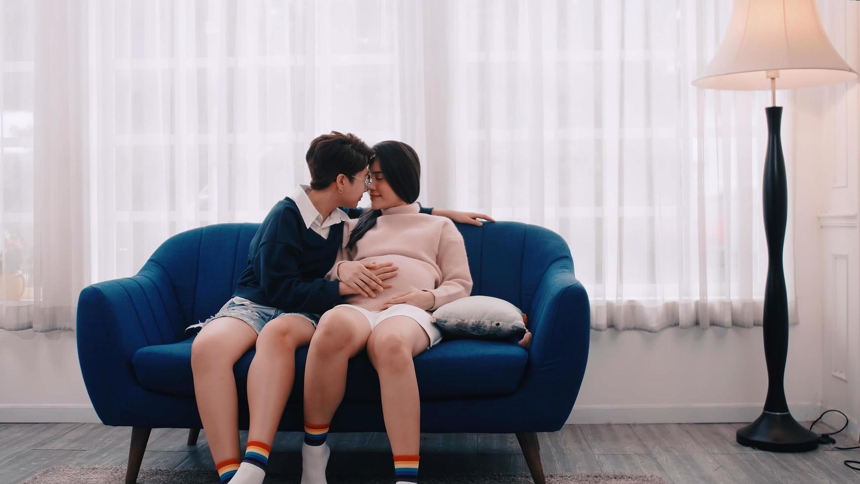 Pregnant Asian lesbian woman and her partner are happy to spend time together at home. photo