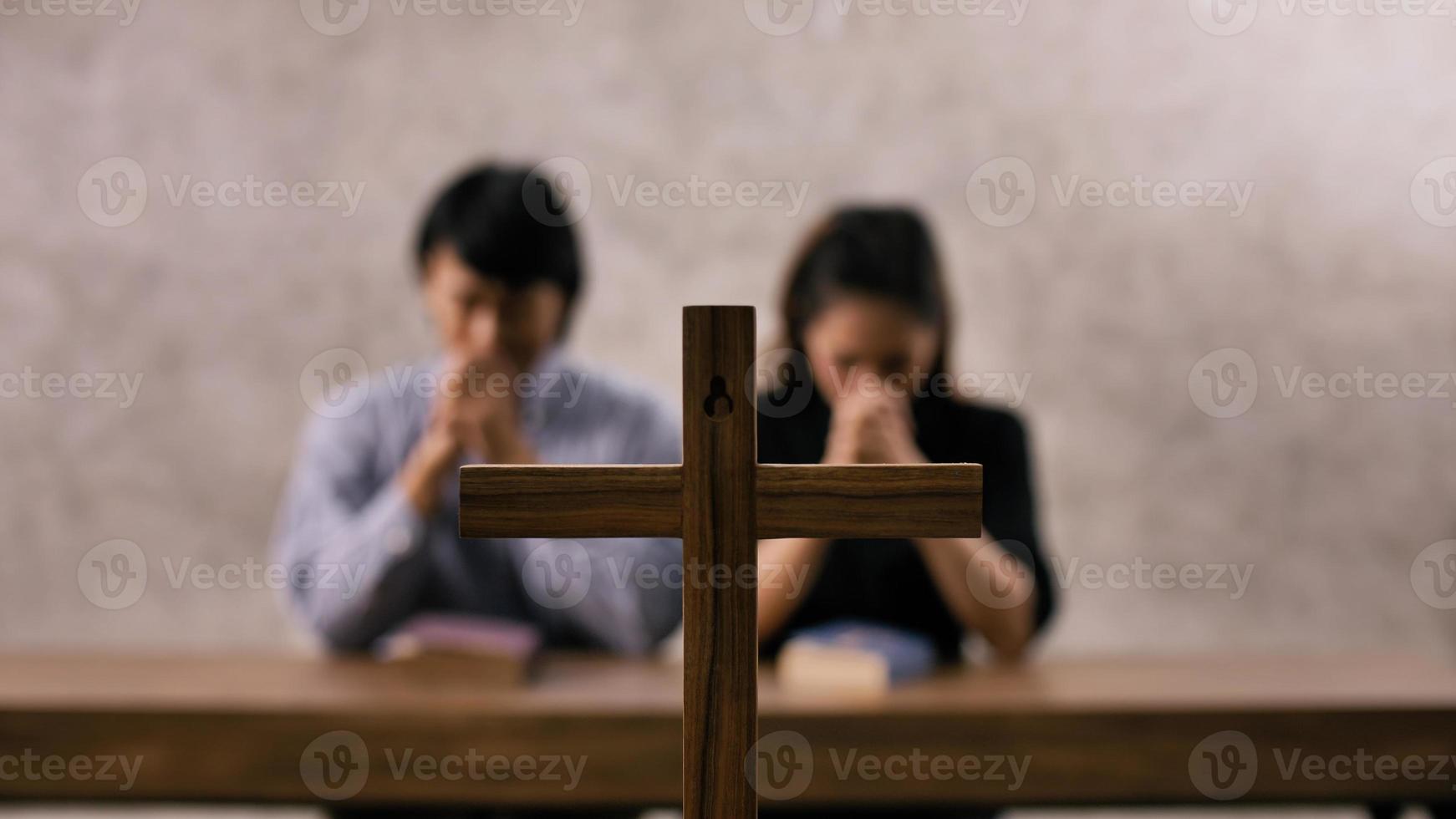 una joven pareja cristiana asiática rezando a jesucristo en una iglesia. foto