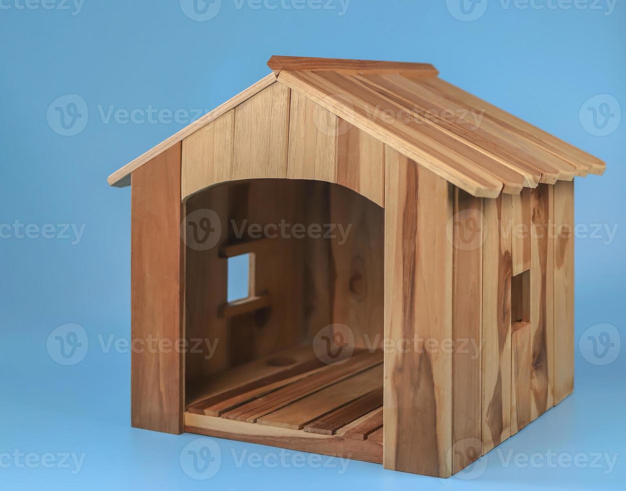 casa de mascota de madera vacía sobre fondo azul. aislado. foto