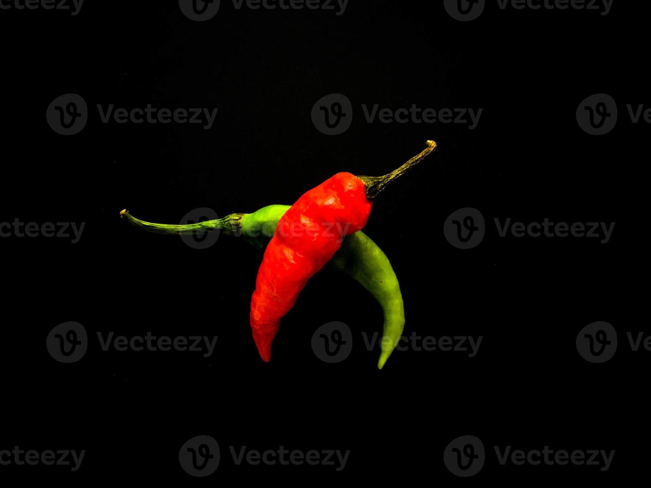 Natural green and red chilies on a dark background. Top view with food background, black stone table, copy space. photo
