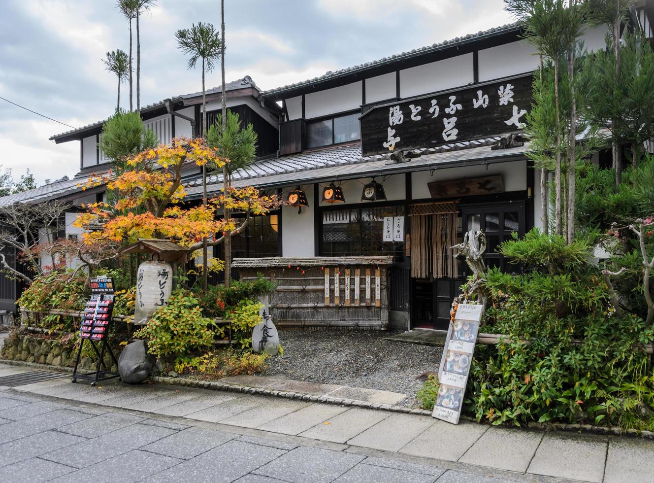 kyoto, japón - 24 de noviembre de 2016 restaurante tradicional japonés de madera en la calle conservada saga-toriimoto en arashiyama, kyoto, japón. una calle histórica bordeada por casas adosadas tradicionales con tiendas foto