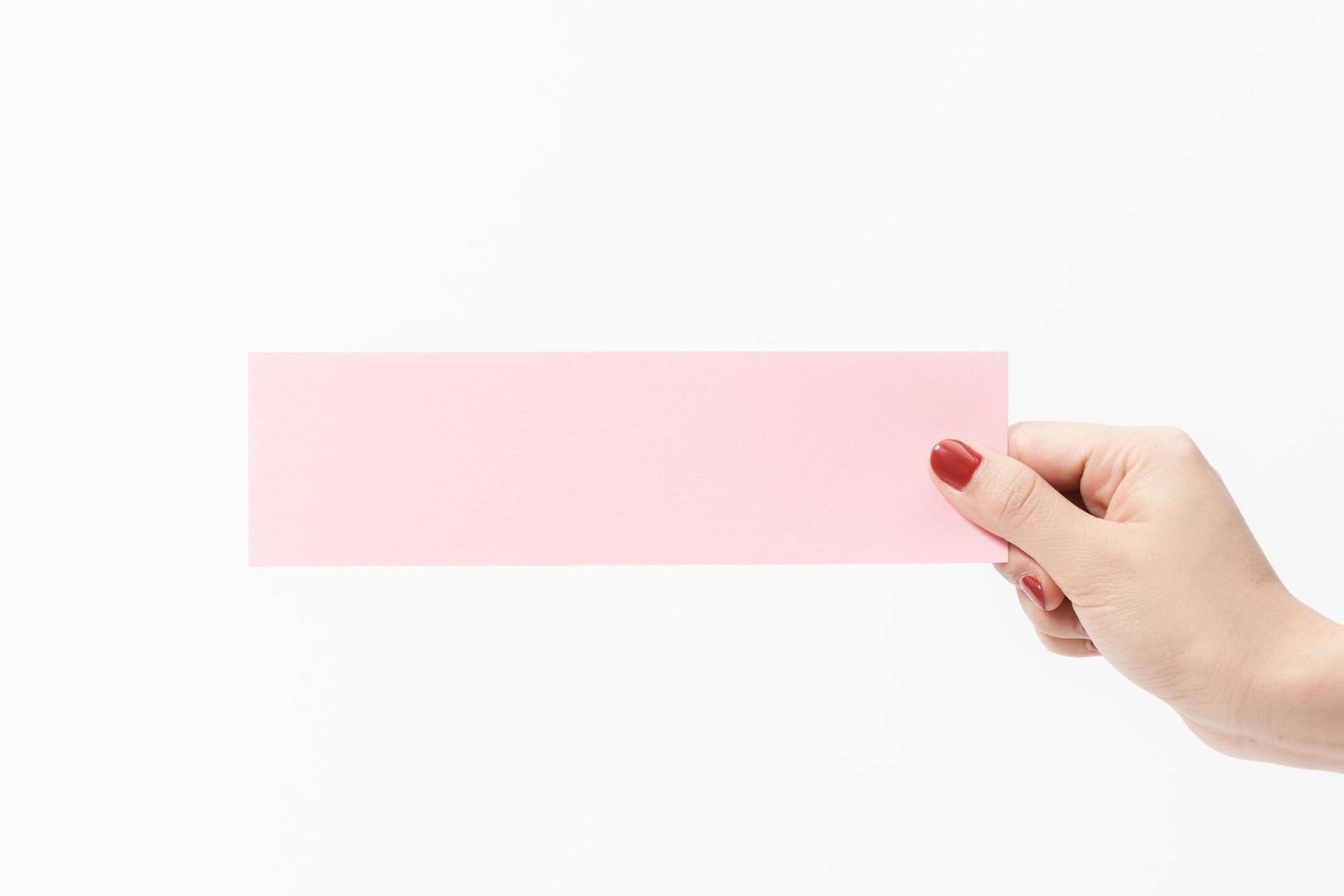 Close up women holding pink blank paper on white background. photo