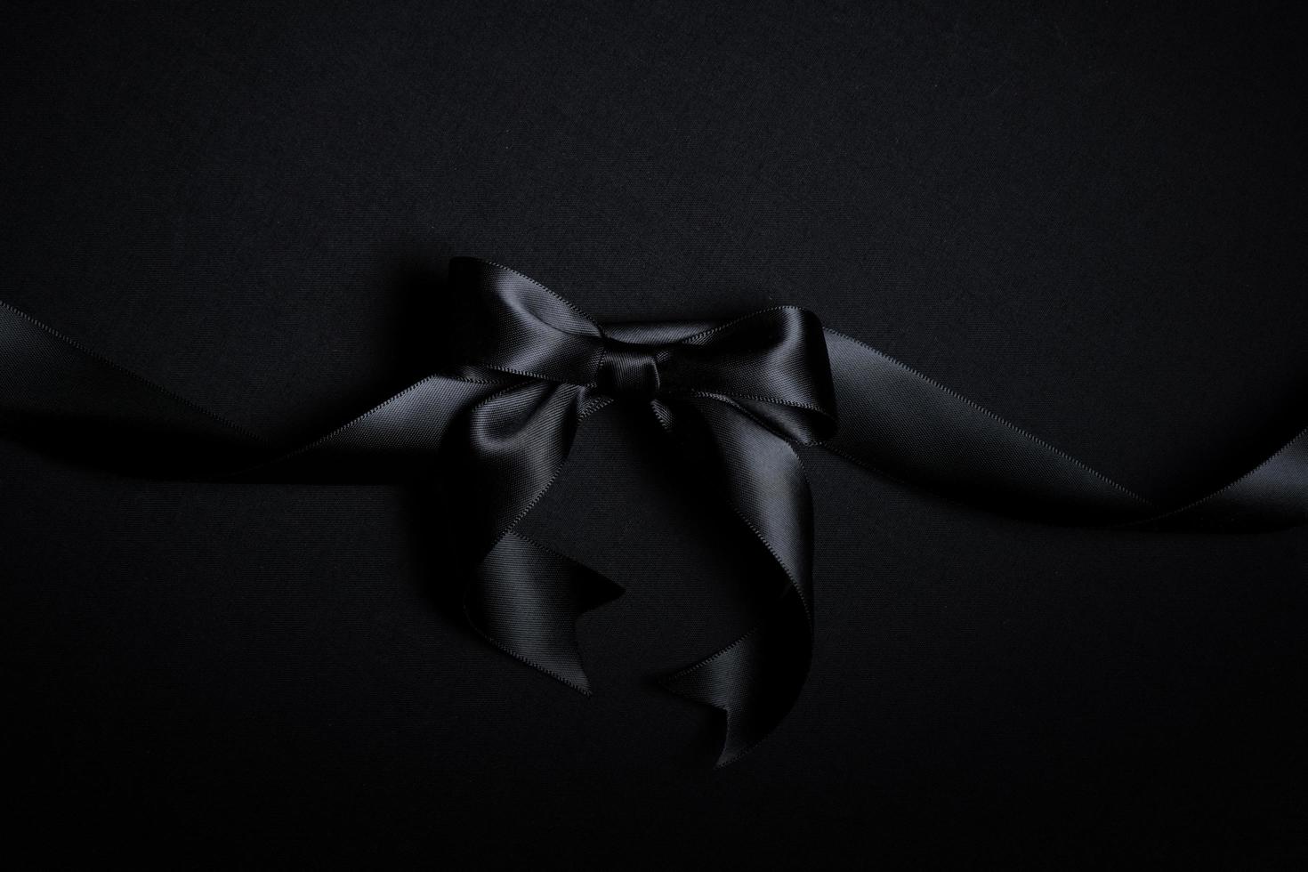 Top view of black ribbon on black background with free copy space for text. photo