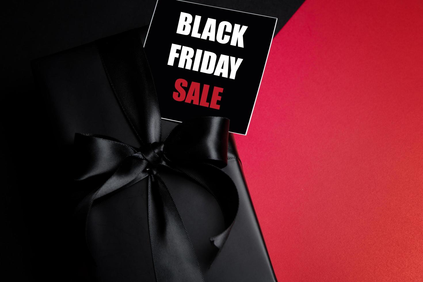 Top view of Black Friday Sale text with black gift box isolated on black background. photo