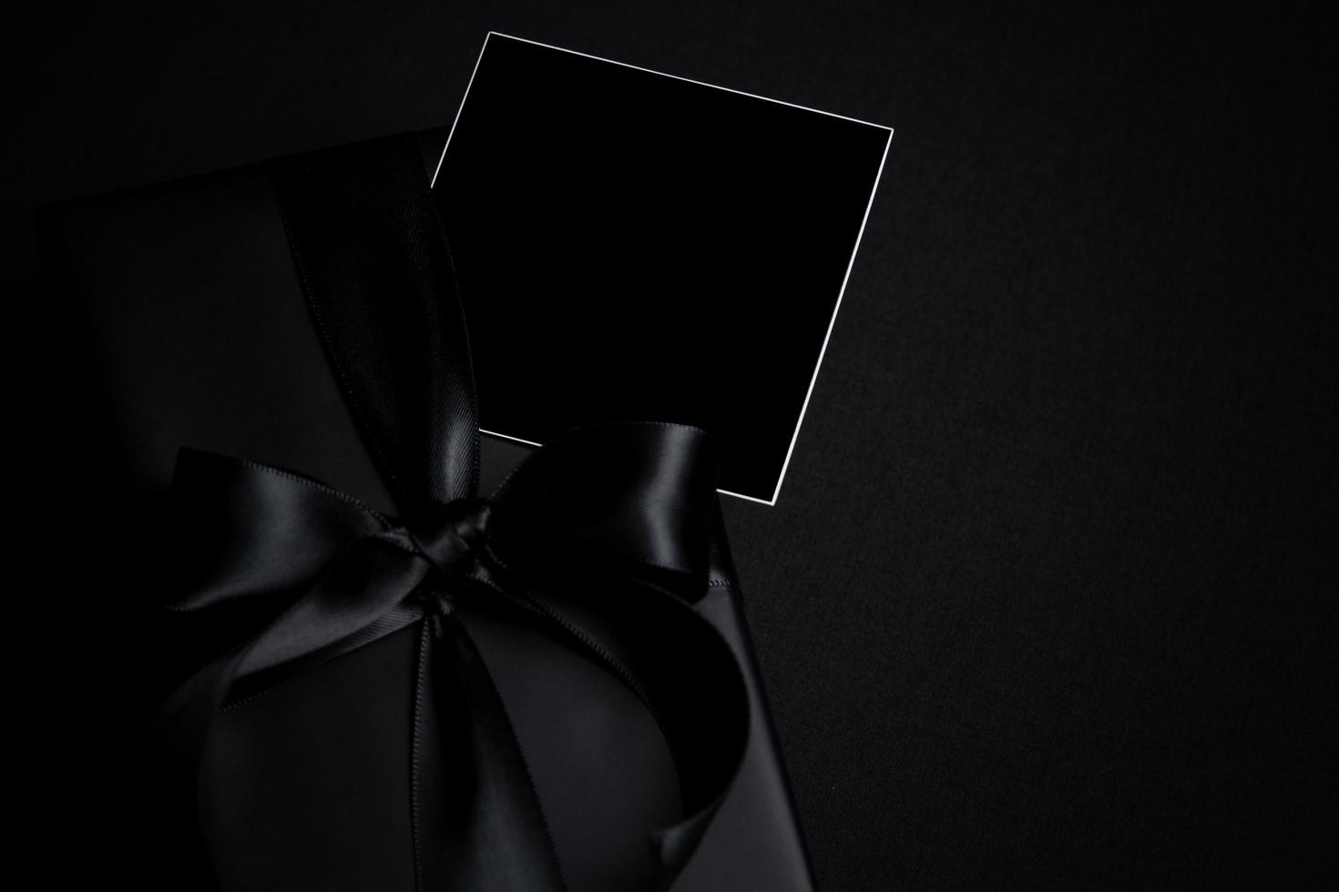 Top view of free space for text with black gift box isolated on black background. photo