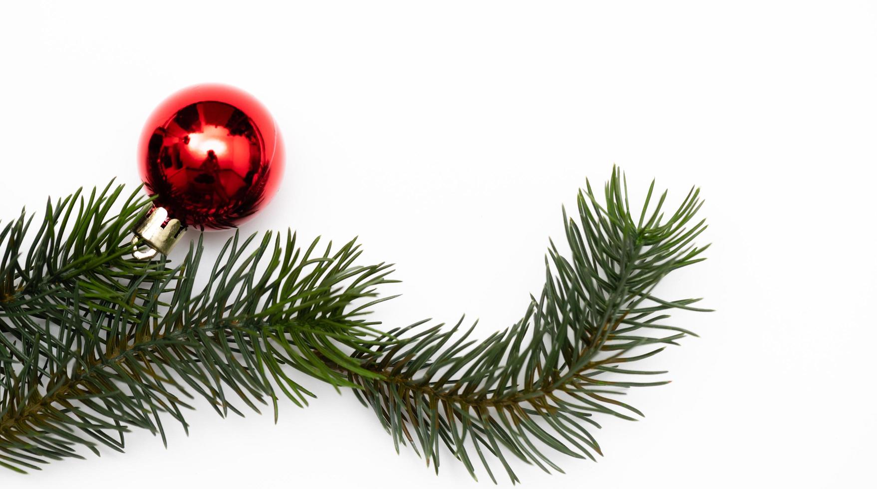 Top view of Christmas gift box red balls with spruce branches, pine cones, red berries and bell on white background. photo