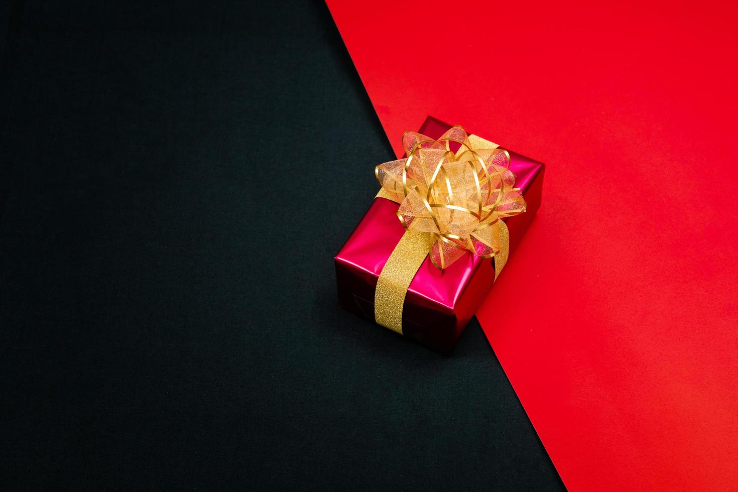 black gift box with black ribbons isolated on black background photo